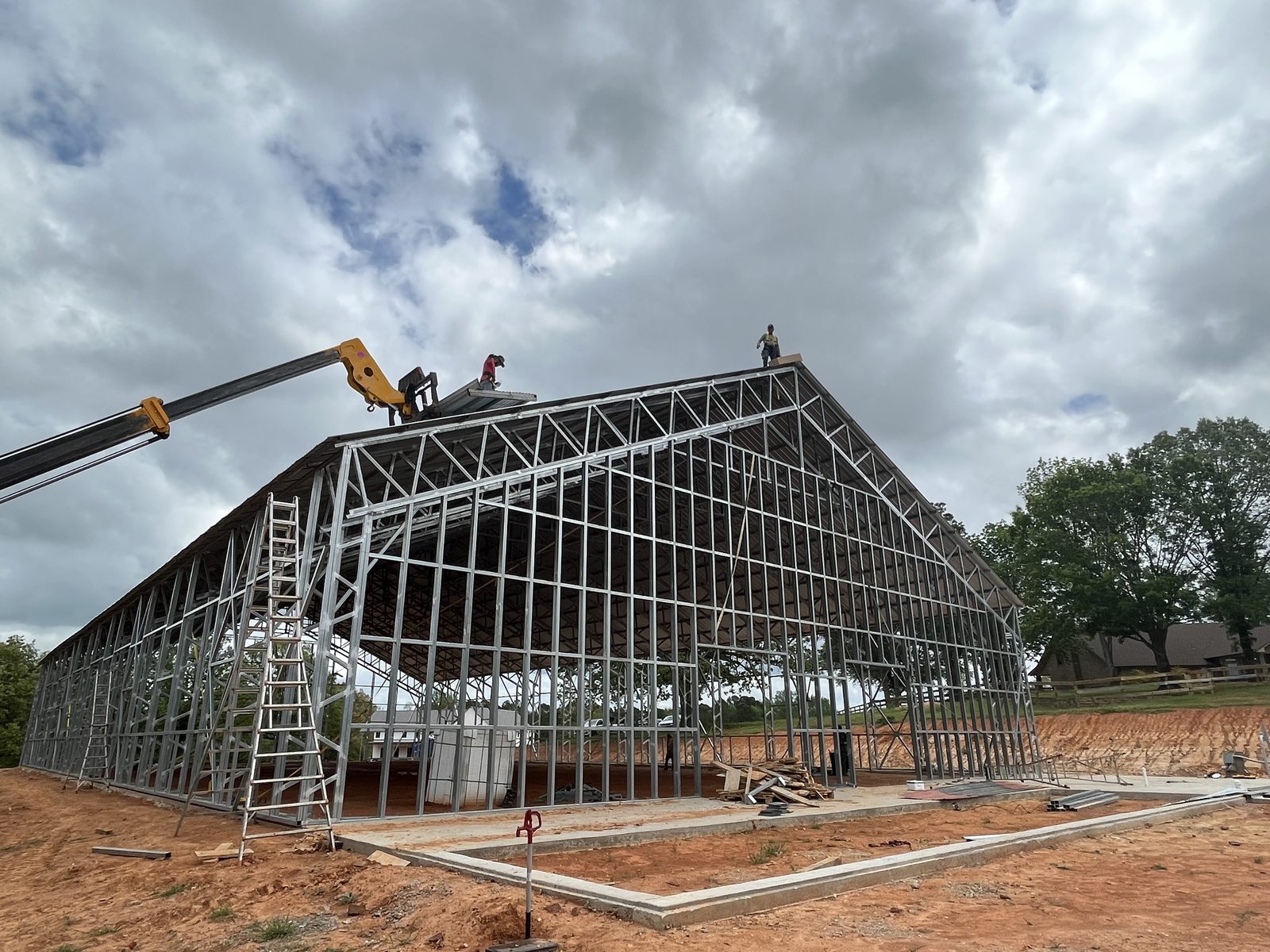 Crane setting roof panels on the equestrian arena frame