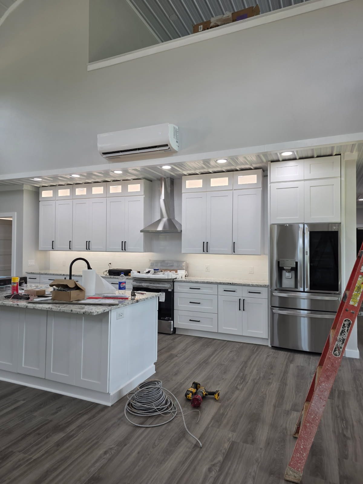 Open-plan kitchen with vaulted ceiling and exposed metal decking in a TubeCrete home